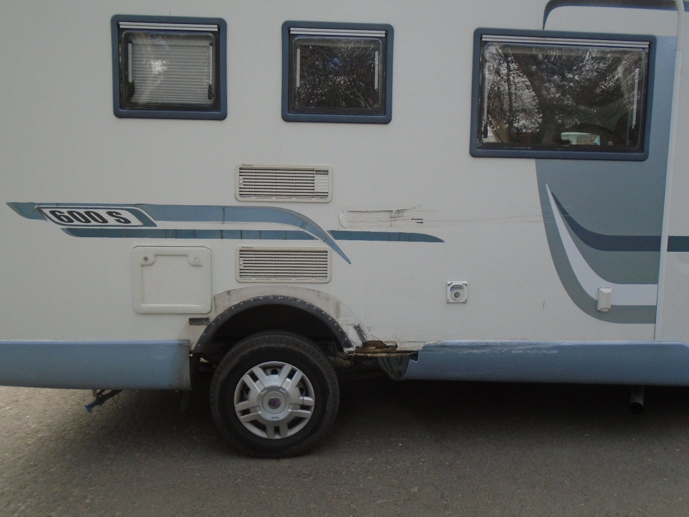Motorhome with damaged lower side skirt and wheel arch